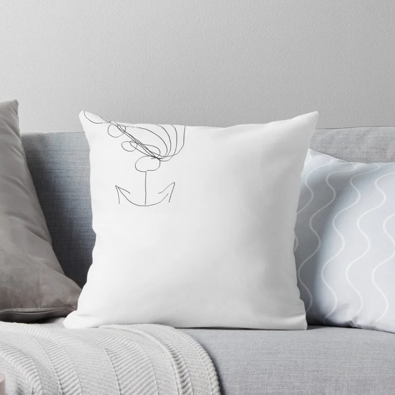 A white cushion with a single line drawing on a bed